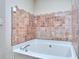 Close-up of a soaking tub with decorative tiling and modern fixtures at 5640 Terremont Cir, Norcross, GA 30093