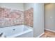 Luxurious soaking tub with decorative tile surround, perfect for relaxation at 5640 Terremont Cir, Norcross, GA 30093