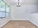 Bright dining area with modern chandelier, wood floors, and natural light from a large window at 5640 Terremont Cir, Norcross, GA 30093