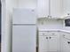 Kitchen with white cabinets, with updated countertops and refrigerator, offering ample storage space at 5640 Terremont Cir, Norcross, GA 30093
