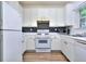 Well-lit kitchen with white cabinets, stainless steel appliances, and a black tile backsplash at 5640 Terremont Cir, Norcross, GA 30093