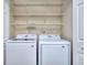 Modern laundry room featuring a side-by-side washer and dryer, and wire shelving at 5640 Terremont Cir, Norcross, GA 30093