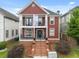 Charming two-story home featuring double balconies, brick stairs, and lush landscaping at 121 Fulton Se Way, Atlanta, GA 30312