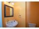 Stylish half bathroom featuring a pedestal sink and a framed mirror at 1215 Harris Commons Pl, Roswell, GA 30076