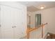 Upstairs hallway featuring wood railing, carpeted floors, and white double doors at 1215 Harris Commons Pl, Roswell, GA 30076
