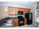 Kitchen featuring black appliances, wood cabinets, and a window for natural light at 1215 Harris Commons Pl, Roswell, GA 30076