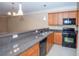Kitchen with granite countertops, stainless steel appliances, and wood cabinets at 1215 Harris Commons Pl, Roswell, GA 30076