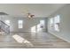 Large light-filled living room with wood-style flooring, stairs, and multiple windows at 349 Heavenly Hollow Pl, Mcdonough, GA 30253