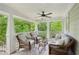 Inviting covered porch featuring cozy wicker furniture, a ceiling fan, and views of the surrounding lush greenery at 443 Lakeshore Ne Dr, Atlanta, GA 30307