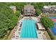 Aerial view displays a large community pool with lounge chairs, surrounded by lush greenery and trees at 503 Mill Ridge Rd, Woodstock, GA 30188