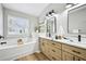 Bright bathroom featuring double sinks, modern finishes, and a soaking tub at 503 Mill Ridge Rd, Woodstock, GA 30188