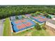 Aerial view of the community tennis courts showcases well-maintained blue and red surfaces and lush landscaping at 503 Mill Ridge Rd, Woodstock, GA 30188
