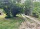Long gravel driveway leads to a rural home through a lush green landscape at 7000 Petersburg Rd, Fairburn, GA 30213
