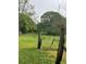 Spacious grassy field with rustic fence posts and natural beauty, perfect for outdoor activities at 7000 Petersburg Rd, Fairburn, GA 30213