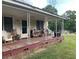 Covered front porch with weathered wood, supports, and comfortable seating at 7000 Petersburg Rd, Fairburn, GA 30213