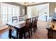 Dining room with wood table and chairs, shutters, and view to stairs at 109 Lighthorse Blvd, Mcdonough, GA 30252