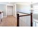 Upstairs hallway with wood railing, carpet, chandelier and lots of natural light at 109 Lighthorse Blvd, Mcdonough, GA 30252