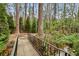 A quaint backyard bridge leads to a peaceful stream surrounded by lush greenery at 258 Pineland Nw Rd, Atlanta, GA 30342