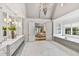 A spacious bathroom featuring a vaulted ceiling, soaking tub, herringbone tile floor, and bedroom view at 258 Pineland Nw Rd, Atlanta, GA 30342