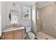 Bathroom featuring a glass shower, wooden under-sink cabinets and a hexagon mirror at 258 Pineland Nw Rd, Atlanta, GA 30342