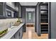Stylish butler's pantry with marble countertops, custom cabinetry, and wood flooring at 258 Pineland Nw Rd, Atlanta, GA 30342