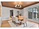 Dining room with hardwood floors, wood ceiling, modern chandelier, and a large window at 258 Pineland Nw Rd, Atlanta, GA 30342