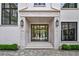 Elegant home entrance featuring a black grid-style glass front door, stone trim, and modern outdoor lighting at 258 Pineland Nw Rd, Atlanta, GA 30342