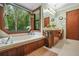 Tranquil bathroom features a soaking tub with a beautiful view of lush greenery at 2666 Peachtree Walk, Duluth, GA 30096