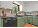 Well-lit kitchen featuring sage green cabinets, black countertops, and modern appliances at 2666 Peachtree Walk, Duluth, GA 30096