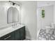 Stylish bathroom with dark green vanity, black and white geometric flooring, and a well lit mirror at 2201 Logan Dr, Jonesboro, GA 30236