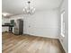 Bright dining area featuring stainless steel appliances, wood floors, and a modern chandelier at 2201 Logan Dr, Jonesboro, GA 30236