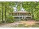 Charming home featuring a spacious front porch and landscaped front yard surrounded by mature trees at 62 Sweetwater Pkwy, Powder Springs, GA 30127