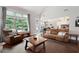 Open-concept living room with a large window, hardwood floors, and a comfortable leather sofa at 6329 Granbury Walk, Acworth, GA 30101