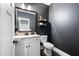 Stylish powder room with a modern vanity, granite countertop, and dark gray walls at 6329 Granbury Walk, Acworth, GA 30101
