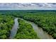 A high angle aerial view shows river meandering through a thick forest, city skyline in the background at 1385 Northcliff Trce, Roswell, GA 30076