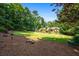 A large grassy backyard with mature trees, mulch, and meticulously maintained landscaping at 1385 Northcliff Trce, Roswell, GA 30076