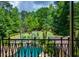 Beautiful backyard view from balcony overlooks lush landscaping, swimming pool, and wooded property at 1385 Northcliff Trce, Roswell, GA 30076