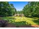 A large grassy backyard with mature trees and meticulously maintained landscaping at 1385 Northcliff Trce, Roswell, GA 30076