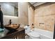 Modern bathroom features unique vessel sink, wooden vanity, and a stylish shower-tub combo at 1385 Northcliff Trce, Roswell, GA 30076