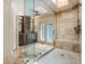 Luxurious bathroom featuring a glass shower, stone tiling, and a double-vanity at 1385 Northcliff Trce, Roswell, GA 30076