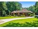 Beautifully maintained property with lush green lawn, long driveway and mature landscaping at 1385 Northcliff Trce, Roswell, GA 30076