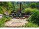 Charming stone patio area with built-in rock seating and lush landscaping at 1385 Northcliff Trce, Roswell, GA 30076