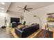 A cozy living room features a sectional sofa, area rug, TV, ceiling fan, and pinball machine at 1385 Northcliff Trce, Roswell, GA 30076