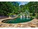 Backyard pool with lush landscaping and small waterfall feature at 1385 Northcliff Trce, Roswell, GA 30076