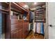Custom walk-in closet featuring rich wood cabinetry, ample storage, and stylish wallpaper accents at 1385 Northcliff Trce, Roswell, GA 30076