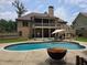 Exterior view of home featuring backyard pool, deck, screened porch, and mature trees at 212 Wilshire Ter, White, GA 30184