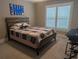 Bedroom features a mixed-wood bed frame with cozy bedding and shuttered windows for natural light at 212 Wilshire Ter, White, GA 30184
