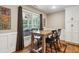 Dining area featuring a table with four chairs, hardwood floors, and a view of the screened patio at 212 Wilshire Ter, White, GA 30184