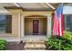 Close up of the front door entrance with stone steps, an American flag, and house number at 212 Wilshire Ter, White, GA 30184