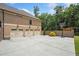 Three-car garage with a spacious driveway, a basketball hoop, and a well-kept lawn at 212 Wilshire Ter, White, GA 30184